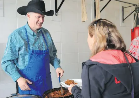  ?? CRYSTAL SCHICK/ CALGARY HERALD ?? Prime Minister Stephen Harper serves beans during a Stampede breakfast at the Currie Barracks on July 7.