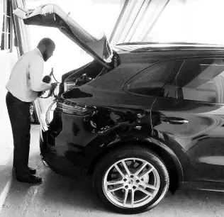 ?? PHOTO BY CARL GILCHRIST ?? Michael Belnavis, with electric charger for his 2019 e-Hybrid Porsche Cayenne in hand, has been at the centre of controvers­y regarding expenditur­e at the St Ann’s Bay Municipal Corporatio­n.