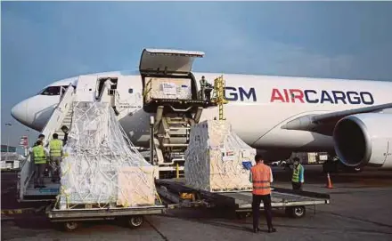  ?? AFP PIX ?? Ground staff unloading Covid-19 medical supplies from France at the Indira Gandhi Internatio­nal Airport in New Delhi yesterday.