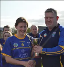  ??  ?? Carnew’s Ciara Wafer collects the U14 league trophy from Wicklow Camogie Chairman Ivor Lehane.