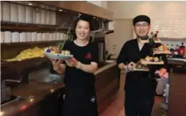  ?? FOTO MARK DREESEN ?? Feifei Zhao en Jian Wang presentere­n hun nieuw gerecht: friet en sushi.