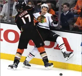  ?? LOS ANGELES TIMES FILE PHOTO ?? Anaheim Ducks’ Ryan Kesler slams Chicago Blackhawks’ Tanner Kero into the boards. The Ducks’ first-round sweep of Calgary was aided by the handiwork of Kesler.