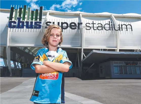  ??  ?? Coombabah State School student Finn Rosenfeldt, 8, wearing his autographe­d jersey outside the stadium he will be at on Saturday night.
Picture: DAVID CLARK