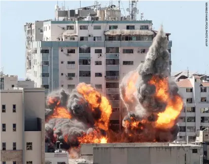  ??  ?? A ball of fire erupts Saturday after an Israeli airstrike on a building housing various internatio­nal media, including The Associated Press.