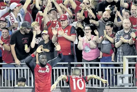  ?? FRANK GUNN/THE CANADIAN PRESS ?? Toronto FC forward Jozy Altidore celebrates his goal with teammate Sebastian Giovinco as fans cheer on during second half MLS soccer action against the D.C. United, in Toronto on June 17.