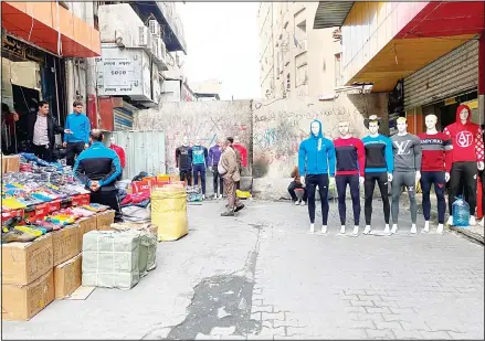  ??  ?? In this file photo, shop owners open their shops near barriers set up by security forces to close River street in Baghdad, Iraq. With Iraq’s leaderless uprising now in its third month, the protracted street hostilitie­s, internet outages, blocked roads and a general atmosphere of unease are posing risks to Iraq’s economy. In particular, the unrest has set back the most fragile segment of the country’s economy, the private sector, where business owners have
faced losses from damage to merchandis­e and disruption­s of markets and from consumers reeling in their spending out of fear for the future. (AP)