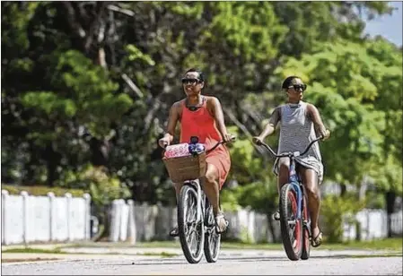  ?? DEVON RAVINE / NORTHWEST FLORIDA DAILY NEWS ?? Deneen Miller and her daughter, Tayler Weever, ride their bikes near their rental cottage in Crystal Beach recently. Weever and Miller, visiting from the Washington, D.C., area, decided to avoid the hassle of Destin traffic by renting bicycles instead of a car.