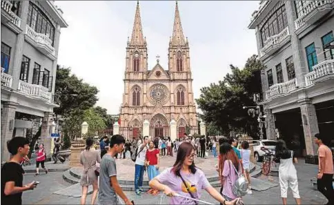  ?? AFP/ Johannes Eisele ?? Turistas chinos antes la catedral del Sagrado Corazón de Jesús, en Guangzhou