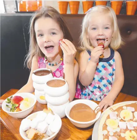  ?? Picture: MIKE BATTERHAM ?? Kaitlin Dennison, 4, and sister Chloe 2, at Max Brenner, Southport are ready for World Chocolate Day.