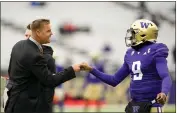  ?? LINDSEY WASSON — THE ASSOCIATED PRESS ?? Former NFL and Washington quarterbac­k Brock Huard, left, greets Washington quarterbac­k Michael Penix Jr., right, before an NCAA college football game against Utah, Nov. 11 in Seattle.