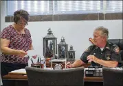  ??  ?? Lucas County Sheriff John Tharp speaks with his assistant, Sandy Heban, in his office in Toledo, Ohio. Police and rescue crews say drivers overdosing on heroin and other drugs are driving up the number of car crashes.