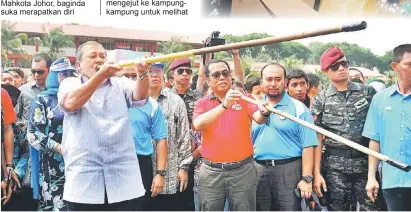  ?? — Gambar Bernama ?? MENCUBA: Sultan Ibrahim berkenan menyumpit bersama Menteri Besar Johor Datuk Seri Mohamed Khaled Nordin di salah satu daerah persinggah­an baginda ketika Kembara Mahkota Johor 2014.