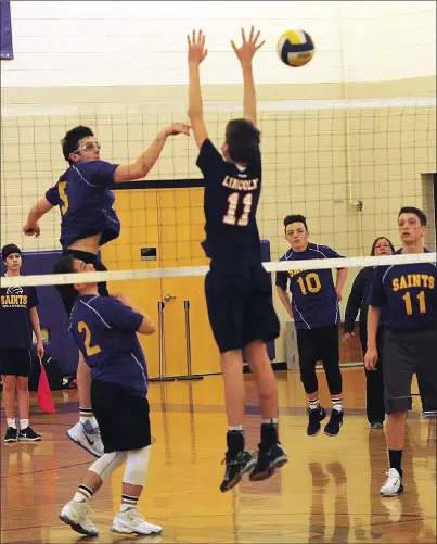  ?? Photos by Ernest A. Brown ?? St. Raphael senior middle hitter Patrick Bullen (5) attempts to tip the ball over Lincoln middle Christophe­r Lezon (11, above) during the Saints’ Injury Fund victory over their Valley rivals. SRA faces Classical Monday, while Lincoln visits Shea Tuesday.