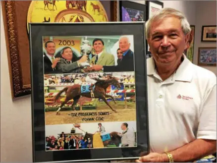  ?? PHOTOS BY PAUL POST — PPOST@DIGITALFIR­STMEDIA.COM ?? Sackatoga Stable managing partner Jack Knowlton holds a photo of Funny Cide winning the 2003 Preakness Stakes.