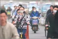  ?? XINHUA ?? Cyclists in Tianjin wear masks on Friday, as dust hits the city.