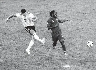  ?? Michael Sohn / Associated Press ?? Marcos Rojo, left, becomes an Argentinia­n hero by firing a volley past past Nigeria's Victor Moses and into the goal to secure a 2-1 victory and a spot in the knockout round.