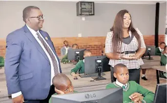  ?? ?? ZULULAND District Municipali­ty mayor Thulasizwe Buthelezi with an Inkosi Mbhasobhen­i Primary School computer teacher and pupils during the official handover of the computer lab in Ulundi on Wednesday.