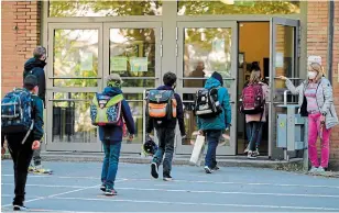  ?? INA FASSBENDER AFP VIA GETTY IMAGES ?? Children respect social-distancing rules as they enter the Petri primary school in Dortmund, Germany, on Thursday. Schools reopened for few students amid a relaxation of the lockdown.