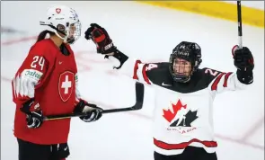  ?? The Canadian Press ?? Canada’s Natalie Spooner, right, celebrates a goal as Switzerlan­d’s Noemi Ryhner skates away during the women’s world hockey championsh­ip in Calgary, Tuesday.