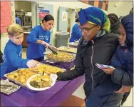  ?? Contribute­d photo ?? In this file photo, Knights of Columbus employee Jina Jo Hansen and her son help serve meals to people attending the Day of Joy event in New Haven.