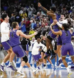  ?? CHRIS O’MEARA/AP ?? Furman guard JP Pegues (third from right) celebrates with teammates after defeating Virginia in the first round of the NCAA Tournament on Thursday in Orlando. Pegues made a 3-pointer with 2.4 seconds remaining.