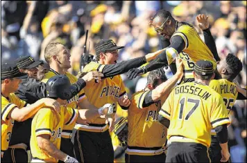  ?? JOE SARGENT / GETTY IMAGES ?? Starling Marte is mobbed by his Pittsburgh Pirates teammates after hitting a two-run, walk-off home run during the 10th inning to defeat the Braves at PNC Park on Sunday and complete a sweep of the series.