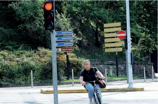  ??  ?? Semafori Capita spesso di incappare in qualche ciclista che di fronte a un semaforo rosso continua la sua marcia, senza preoccupar­si troppo di rispettare le regole. In questo caso la donna in bicicletta imbocca la via con il rosso contromano (LaPresse/...