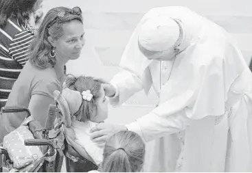  ?? Giorgio Onorati / Associated Press ?? Pope Francis greets a child Wednesday during his weekly general audience at the Vatican.