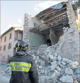  ??  ?? DESTROYED: A firefighte­r looks at a damaged house in the town of Visso after the 5.9 earthquake.