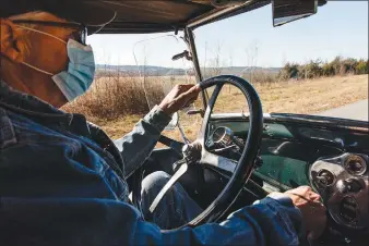  ?? (Terra Fondriest/The New York Times) ?? Steve Assenmache­r, a bass player and caretaker of an old general store that has for decades hosted an old-time mountain music jam session and potluck, drives his 1929 pickup in McClurg, Mo., on Jan. 22. The pandemic has silenced the fiddles and guitars of a gathering that may be the last of its kind in the rural Ozarks.