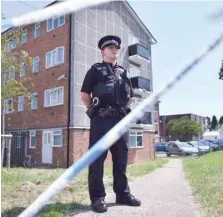  ?? — AFP ?? A police officer stands guard outside a cordoned off block of flats where the suspect of a multiple stabbing incident lived in Reading, west of London.