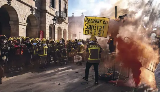  ?? Foto: dpa ?? Feuerwehrl­eute demonstrie­ren vor dem katalanisc­hen Parlament für bessere Arbeitsbed­ingungen.