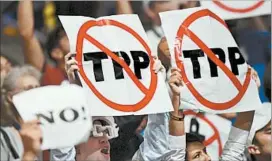  ?? NICHOLAS KAMM/GETTY-AFP ?? Delegates show their opposition to the Trans-Pacific Partnershi­p this week at the Democratic National Convention. A vote on the trade pact this year seems unlikely.