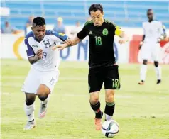  ?? Orlando Sierra / AFP-Getty Images ?? El capitán y mediocampi­sta de la selección mexicana de fútbol, Andrés Guardado (der.), escapa de la marca del volante hondureño del Houston Dynamo Luis Garrido, quien sufrió una grave lesión en la derrota 0-2 del equipo catracho frente al ‘Tri’ el...