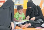  ??  ?? RIGHT A mother reads a book to her son at the TK Park learning centre in Pattani.