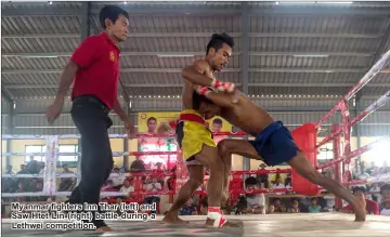  ??  ?? Myanmar fighters Inn Thar (left) and Saw Htet Lin (right) battle during a Lethwei competitio­n.