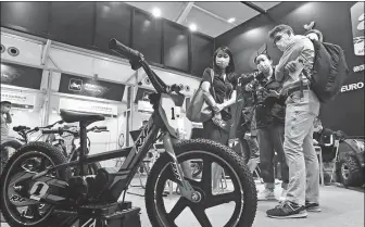  ?? ZHENG ERQI / CHINA DAILY ?? Visitors view a mountain bike on display during the first day of the 130th session of the China Import and Export Fair in Guangzhou on Friday.