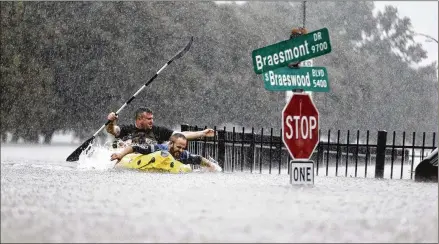  ?? MARKMULLIG­AN / HOUSTON CHRONICLE ?? Two kayakers try to beat the current pushing themdownan overflowin­g bayou in Houston on Sunday. Rescuers answered hundreds of calls as floodwater­s fromthe remnants ofHurrican­e Harvey climbed high enough to begin filling second-story homes.