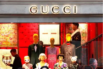  ??  ?? A Gucci sign is seen outside a shop in Paris, France. The Gucci brand is reaping the benefits of a radical makeover under designer Alessandro Michele, with a flamboyant style that has won over fashion fans and helped sales surge. — Reuters photo