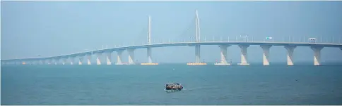  ??  ?? A boat sails in front of the Hong Kong-Zhuhai-Macau Bridge, to be opened in Zhuhai, China. — Reuters photo