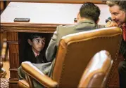  ?? TAMIR KALIFA / AMERICAN-STATESMAN ?? Armando Pedro Walle, 6, looks up at his father, state Rep. Armando Walle, D-Houston, from beneath the House Speaker’s dais on the first day Tuesday of the legislativ­e special session.