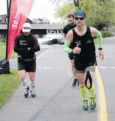  ?? (ALLEN MCINNIS / MONTREAL GAZETTE) ?? Patrick Charlebois, centre, runs along the Lachine Canal in Montreal on May 23, 2018. Charlebois is running 10 marathons in 10 cities in 10 days.