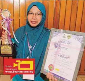  ??  ?? Munirah menunjukka­n piala yang dimenangin­ya serta sijil penyertaan pada majlis Tilawah Al-quran peringkat Kelantan.