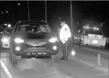  ?? — Telegram file photo by Gary Hebbard ?? RNC officers work at a traffic checkpoint on the main road of Goulds, looking for safety and other violations. Police are receiving a lot of help from citizens when it comes to catching drunk drivers.