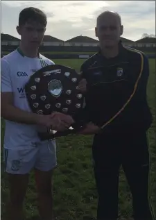  ??  ?? Team captain Conor Firman collecting the South Leinster league title from Patrician (Newbridge) selector Conor Cunnane.