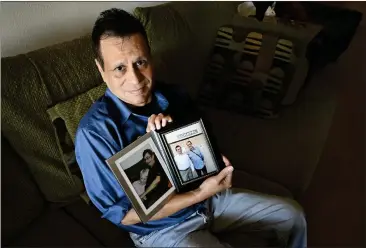  ?? PHOTOS BY BRITTANY MURRAY — STAFF PHOTOGRAPH­ER ?? Dan Diaz sits at his Signal Hill home with photos of his late husband, Robert Morris, and his late mother, Gloria Diaz, on Thursday. Diaz, who cared for both, now struggles because he lives by himself with his own health issues.