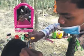  ?? Picture: AFP ?? A CUT ABOVE. A Rohingya Muslim refugee gives a child a haircut at Kutupalong refugee camp in Bangladesh’s Ukhia district.