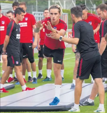  ??  ?? SESIÓN EN MÚNICH. Simeone da instruccio­nes a Griezmann, ayer, en la sesión del Atlético en el Allianz.