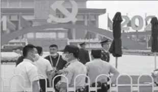  ?? -APP ?? BEIJING
Police chat with each other as they gather near a platform with a Communist Party's logo setup on Tiananmen Square. China is marking the centenary of its ruling Communist Party this week by heralding what it says is its growing influence abroad, along with success in battling corruption at home.