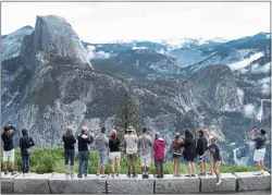  ?? SEAN GALLUP — GETTY IMAGES ?? Visitors look out at Yosemite National Park from Glacier Point in 2014. Glacier Point Road will be closed to all traffic in 2022 to rehabilita­te and improve the road, making Glacier Point only accessible by hiking in.